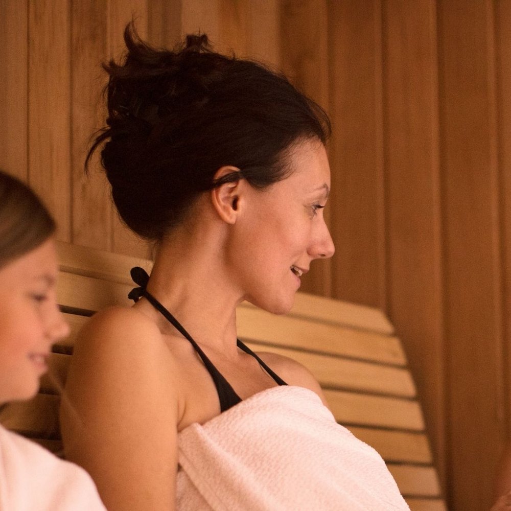 Halloween e Ognissanti Olio Nuovo, Vini e Relax nella Perugia più bella Donna con due bambini seduti su una panca in legno in sauna