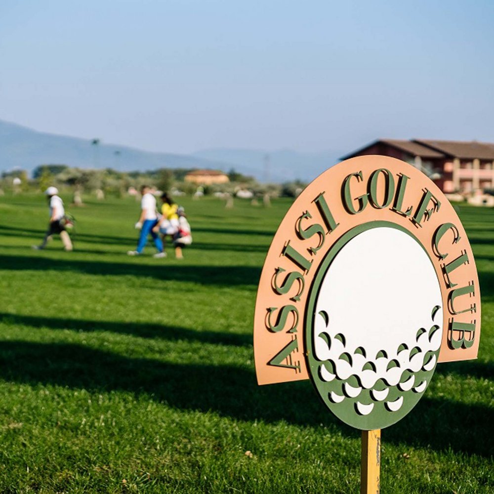 Un hotel a Santa Maria degli Angeli, Assisi? No, molto di più Cartello del Assisi Golf Club su campo da golf con giocatori sullo sfondo