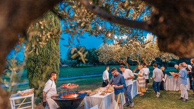 Umbrien: Unterkunft mit Restaurant Menschen bedienen sich an einem Outdoor-Buffet mit Koch am Grill