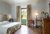 Camera da letto con finestra, letto matrimoniale e arredamento classico in legno.