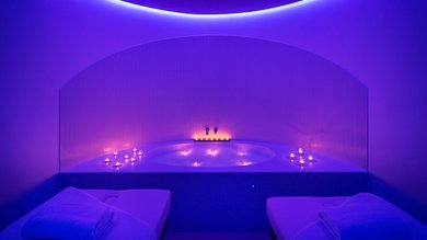 Hotel mit Wellness: Valle di Assisi Spa-Raum mit Whirlpool, brennenden Kerzen und Massageliegen