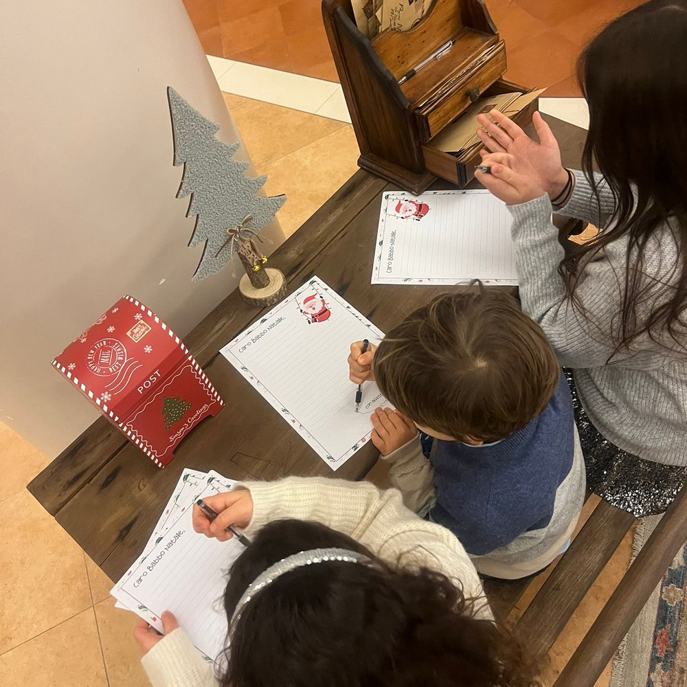 Ponte dell'Immacolata a Valle di Assisi Bambini scrivono lettere a Babbo Natale seduti a un tavolo con cassetta postale natalizia