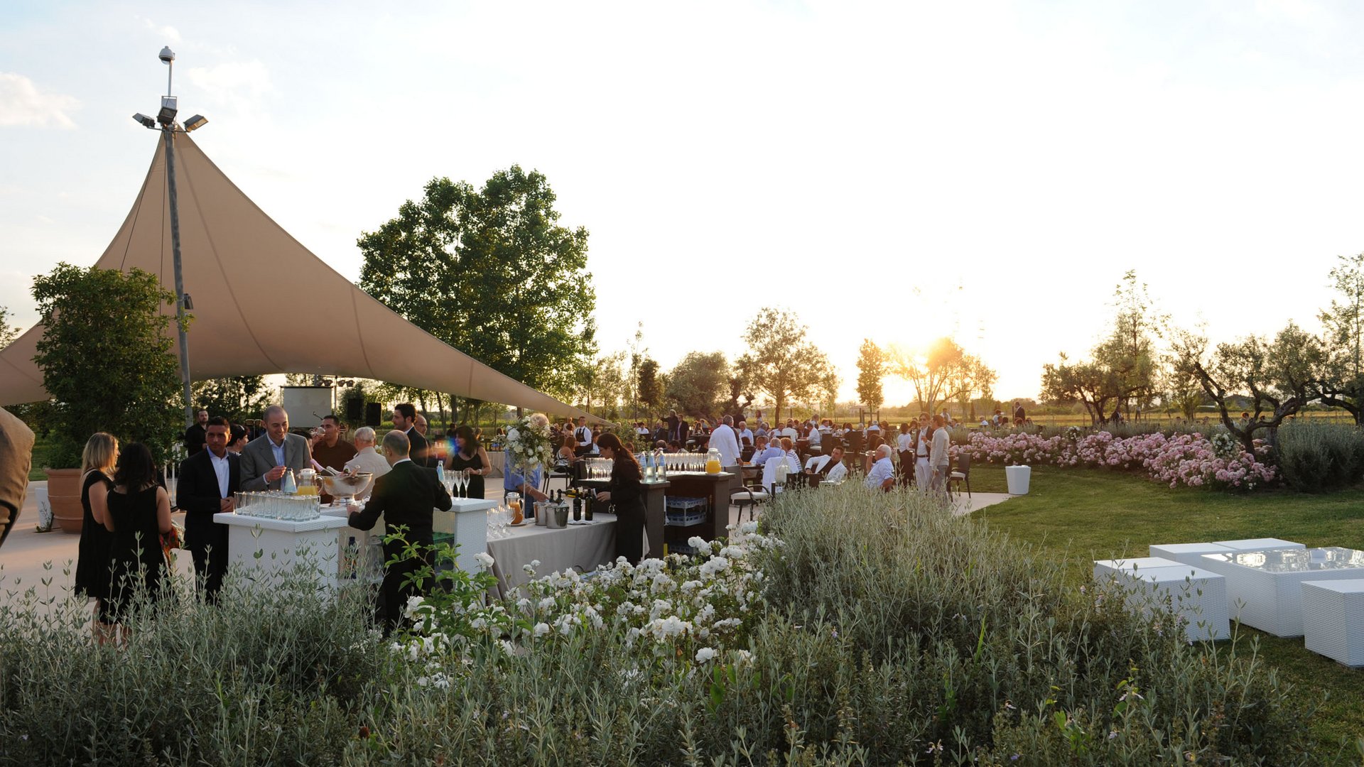 Your wedding location in Assisi Outdoor event at sunset with people socializing and tables with drinks