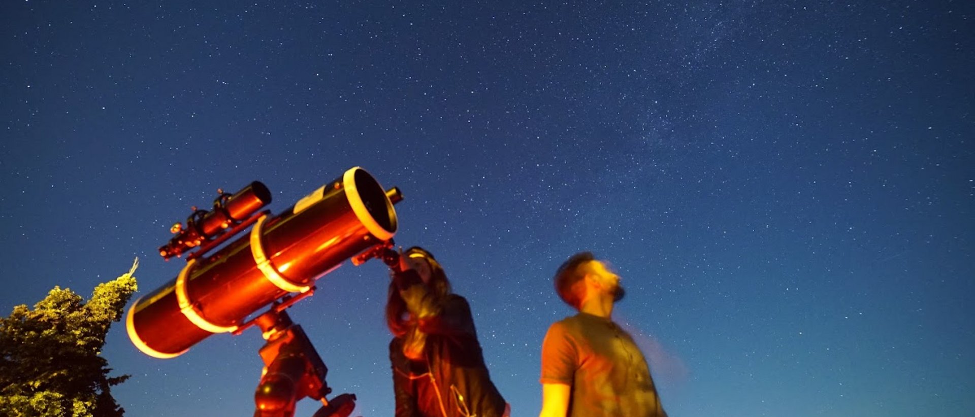 Serata di Astronomia Umbria Assisi con Cena sotto le Stelle Due persone osservano le stelle con un grande telescopio di notte