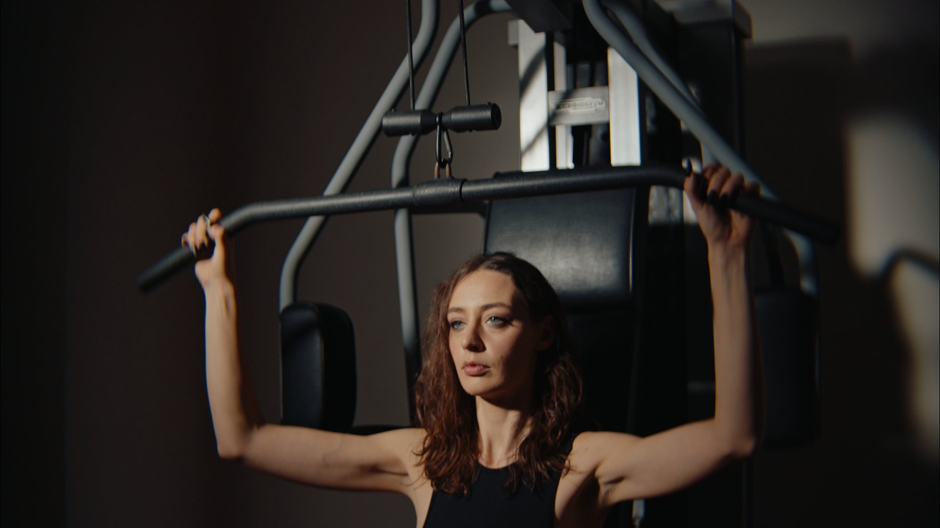 Un hotel con spa per famiglie e area fitness Donna che si allena con macchina per trazioni in palestra