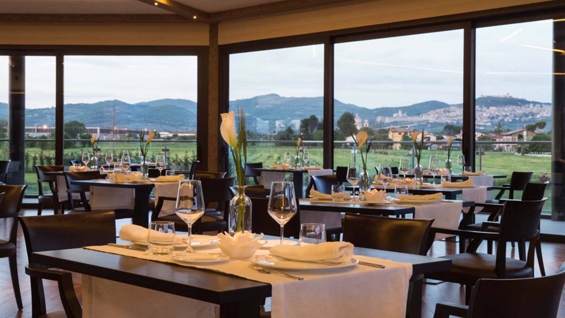 A holiday near Assisi: activities galore Elegant restaurant with set tables and a view of the hills