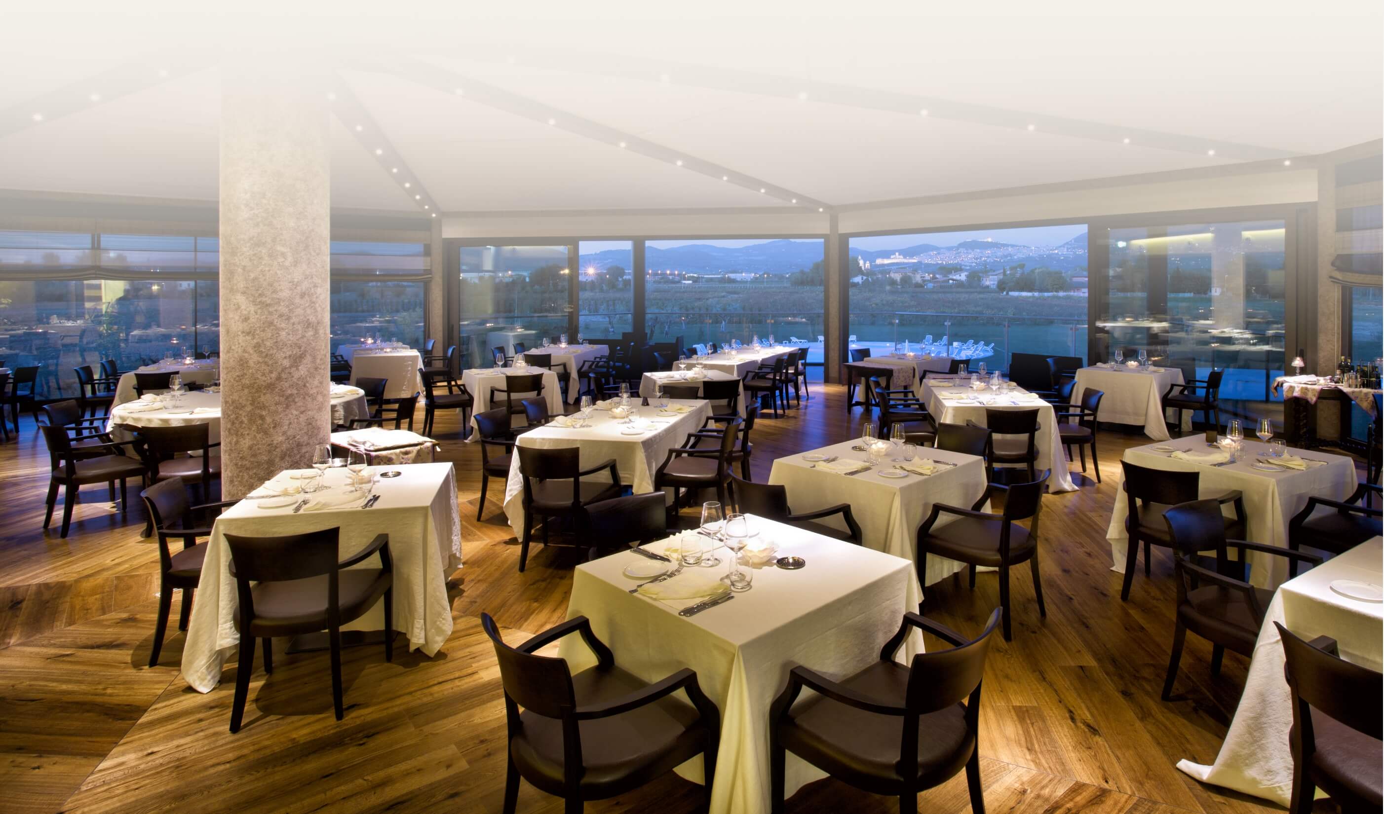 The mission of Valle di Assisi Elegant restaurant with set tables and panoramic views